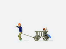 Load image into Gallery viewer, Preiser 28112 HO Scale Man Pulling a Child in a Wooden Cart